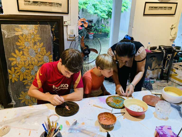 Traveler posing among colorful incense bundles at a Vietnamese incense village