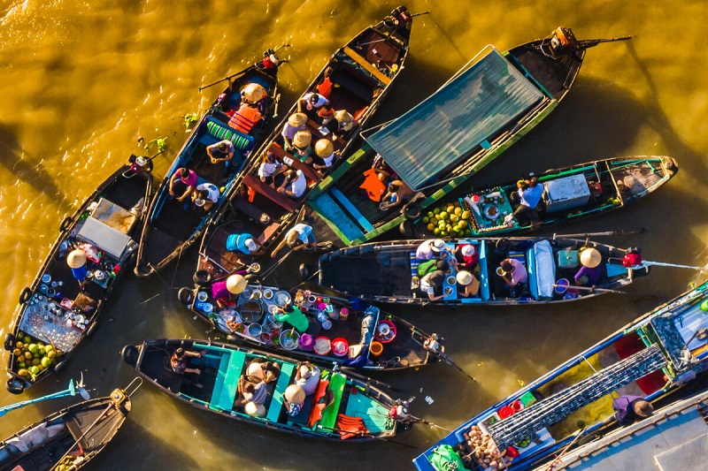 Boats selling fruits and vegetables at Cai Rang Floating Market at sunrise