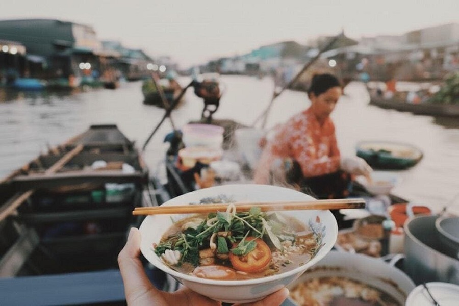 Noodle soup boat serving breakfast on the river at a Mekong Delta floating market