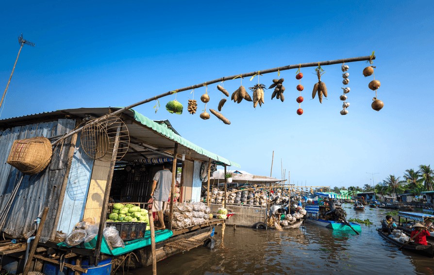 Boat advertising fruit with a “cay beo” pole at a Mekong Delta floating market