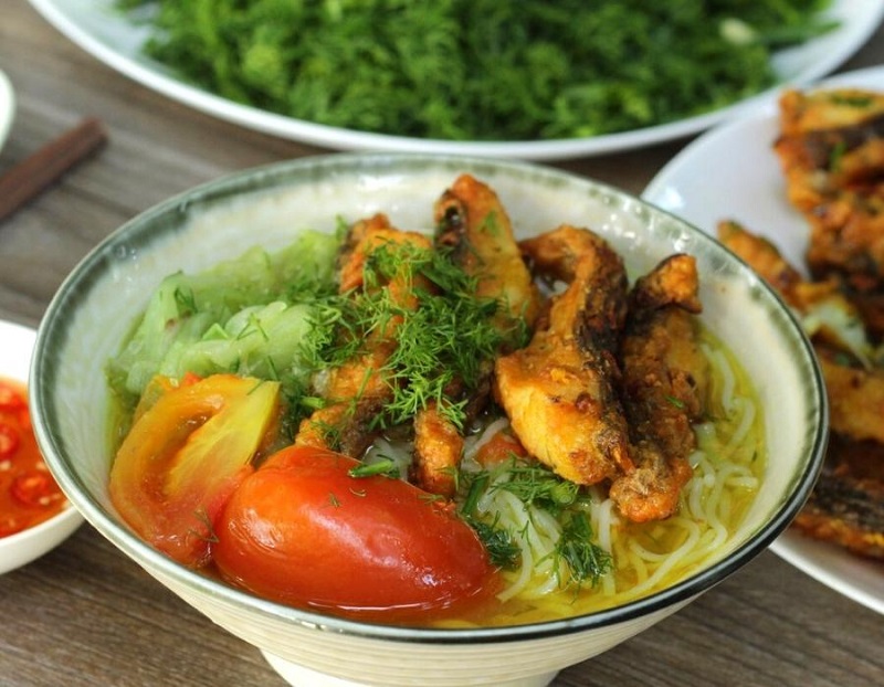 Turmeric fish noodle soup with dill and fresh vegetables