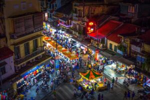 Busy street scene in Hanoi Old Quarter with traditional houses and shops