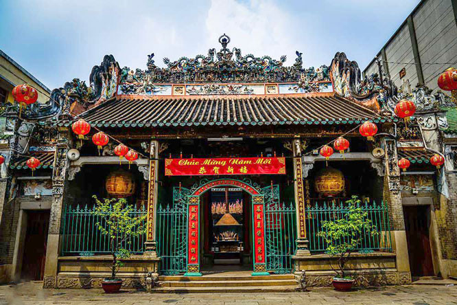 Colorful ancient Vietnamese temple entrance with intricate carvings and traditional architecture.