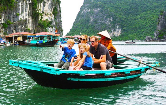Family with children wearing traditional Vietnamese hats during a tailor-made family holiday