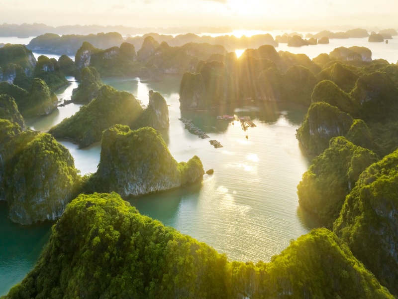 travel guide ha long bay – iconic limestone karsts on emerald water at sunrise