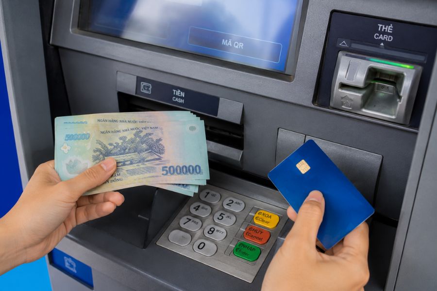 Traveler withdrawing Vietnamese Dong from an ATM in Vietnam