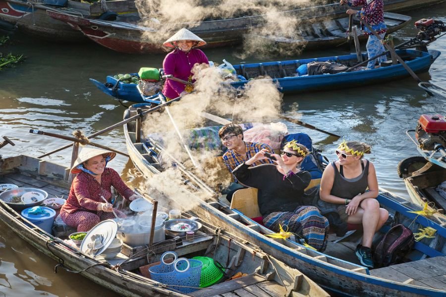 Local vendor selling food from a boat in the Mekong Delta