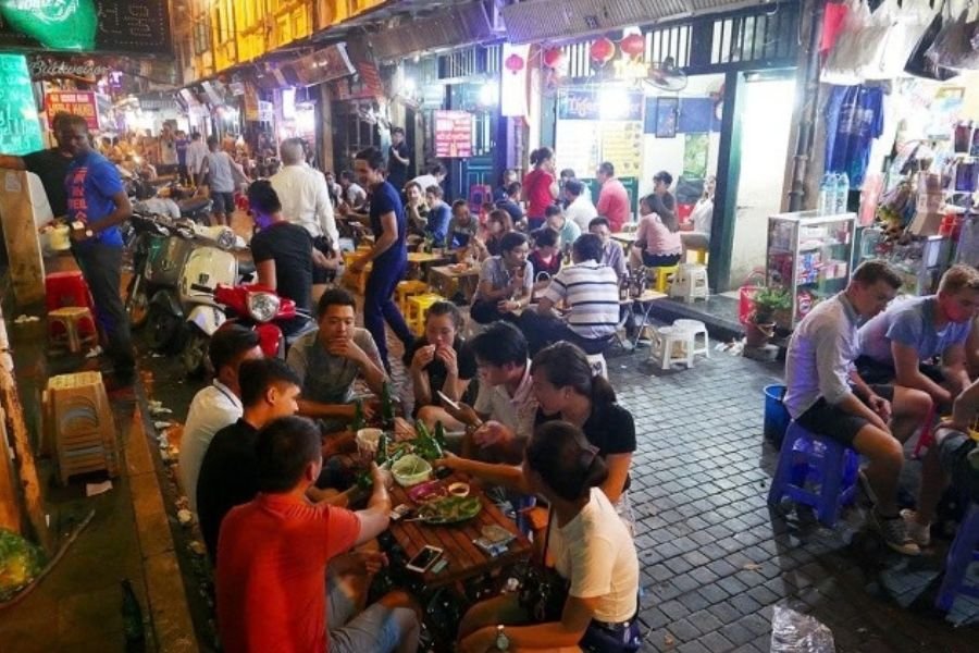 Travelers enjoying local food at a Vietnamese market