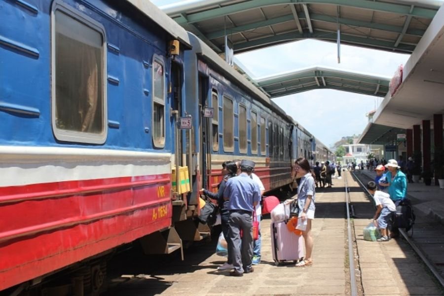Travelers boarding a passenger train at a railway station in Vietnam